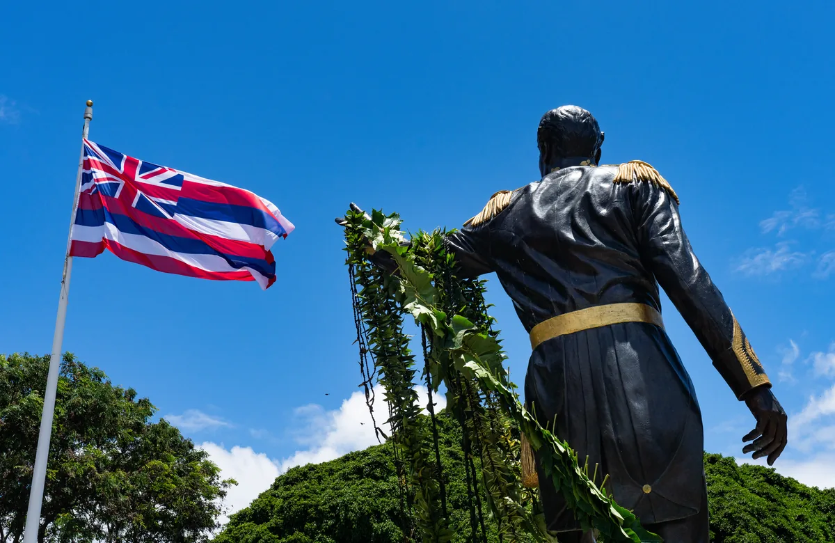 Statue of Kamehameha III beside the Hawaiian flag